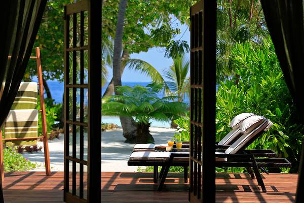 Terrasse mit Lounge-Sesseln im Kurumba Maldives mit Blick auf den Ozean