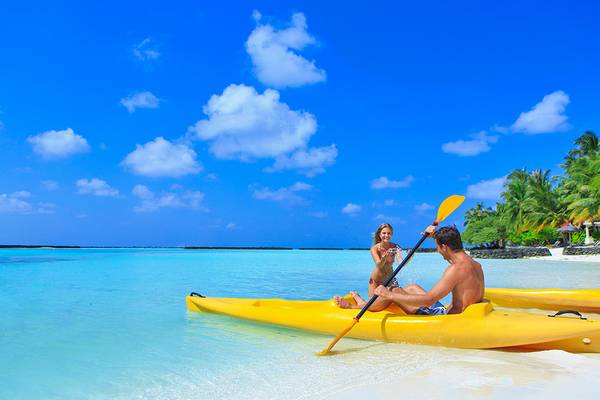 Paar im Kajak am Strand des Kurumba Maldives Hotels