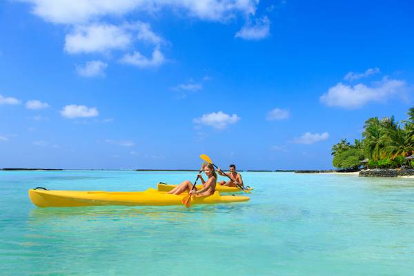Zwei Leute im Kanu paddeln auf dem Wasser vor Kurumba Maldives