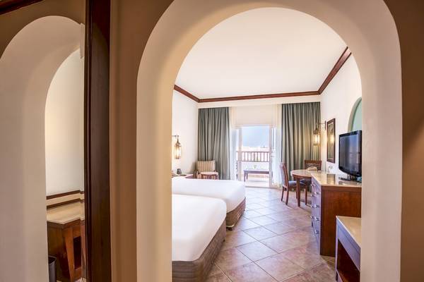 Doppelbettzimmer im Hilton Marsa Alam Nubian Resort mit Blick auf die Terrasse.