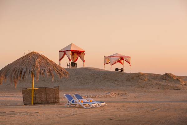 Zwei Zelte und Sonnenliegen am Strand des Hilton Marsa Alam Nubian Resort