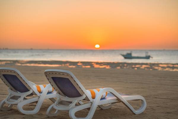 Zwei Liegestühle auf dem Strand des Hilton Marsa Alam Nubian Resorts bei Sonnenuntergang
