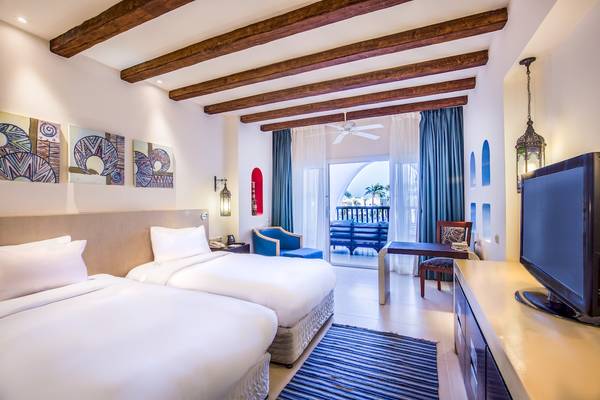 Doppelzimmer im Hilton Marsa Alam Nubian Resort mit zwei Betten und Balkon.