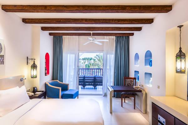 Hotelzimmer im Hilton Marsa Alam Nubian Resort mit Bett, Schreibtisch und Balkon.