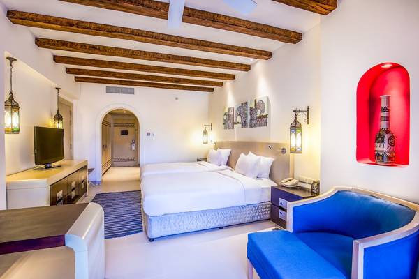 Hotelzimmer im Hilton Marsa Alam Nubian Resort mit zwei Betten, Fernseher, Lampe und Möbeln.