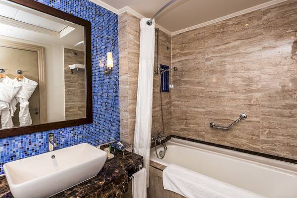 Badezimmer im Hilton Marsa Alam Nubian Resort mit Badewanne, Waschbecken und Spiegel.