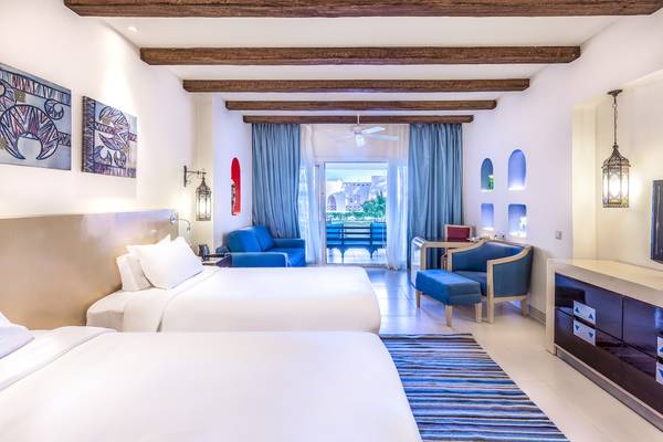Hotelzimmer im Hilton Marsa Alam Nubian Resort mit zwei Betten, einem Sofa, einem Tisch und einer Terrasse.