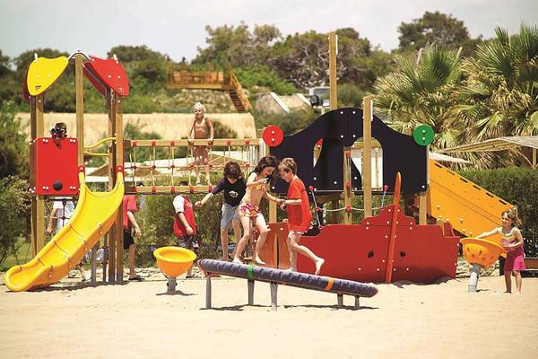 Kinder spielen auf einem bunten Spielplatz im Blue Waters Club Hotel.