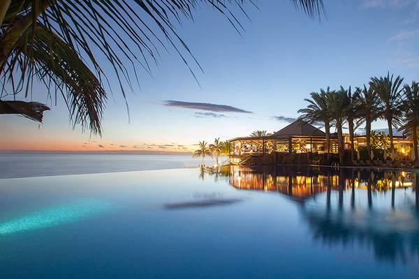 Sonnenuntergang am Lopesan Costa Meloneras Resort & Spa mit Infinity-Pool und Meer im Hintergrund.