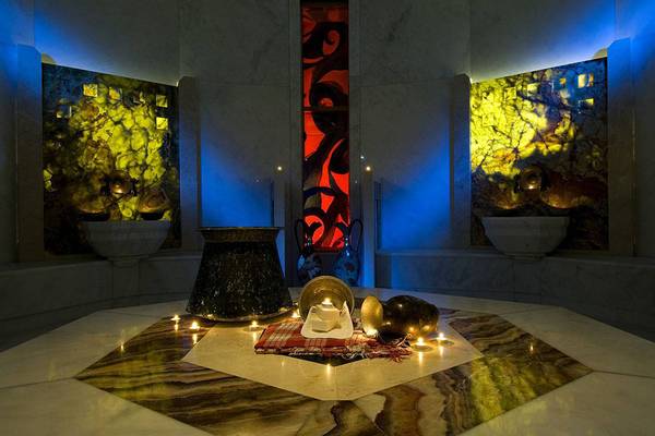 Wellnessbereich im Blue Waters Club mit Marmorwänden, blauen Lichtern und Kerzen.