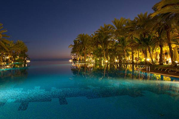 Pool im Lopesan Costa Meloneras Resort & Spa bei Nacht mit Palmen und Lounge-Bereich