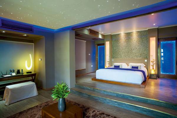 Schlafzimmer im Le Domaine de L'Orangeraie Resort & Spa mit Doppelbett, Nachttisch und Beleuchtung.