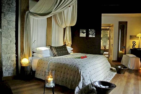 Luxus Schlafzimmer im Le Domaine de L'Orangeraie Resort & Spa mit Baldachin, Kerzen und Steinwand