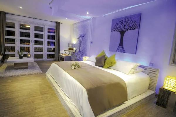 Schlafzimmer im Le Domaine de L'Orangeraie Resort & Spa mit einem Bett, Kissen, Decken, einer Wanddekoration und einem Tisch