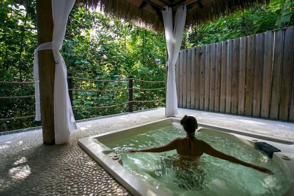 Frau im Außenwhirlpool im Le Domaine de L'Orangeraie Resort & Spa