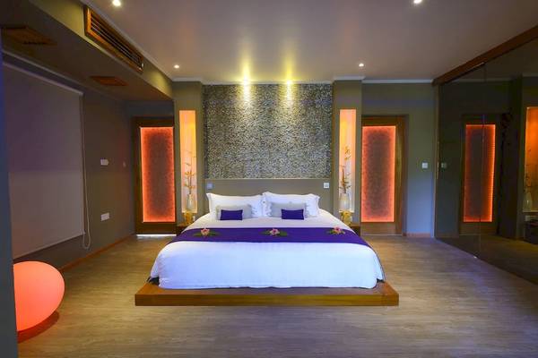 Schlafzimmer im Le Domaine de L'Orangeraie Resort & Spa mit einem großen Bett und orangen Wänden.