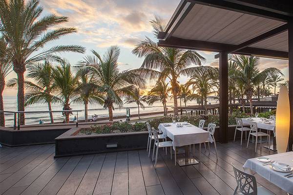 Terrasse des Lopesan Costa Meloneras Resort & Spa mit Blick auf den Ozean und Palmen
