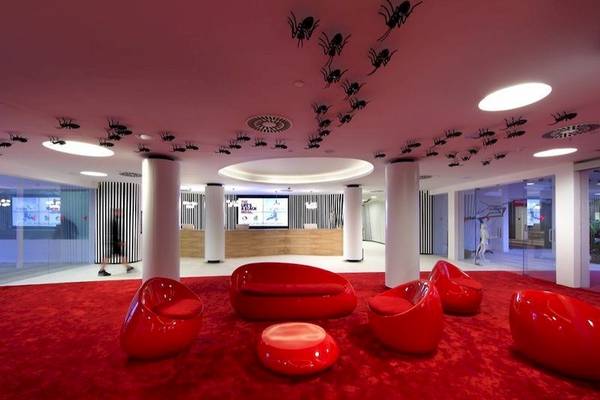 Lobby des Ushuaia Ibiza Beach Hotels mit roten Möbeln und pinker Decke.