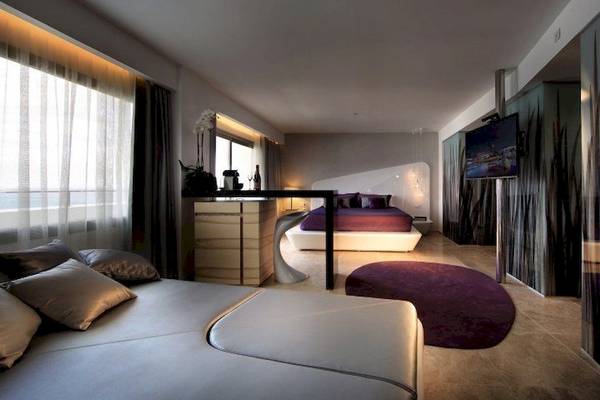 Schlafzimmer im Ushuaia Ibiza Beach Hotel mit Bett, Fernseher und Sofa.