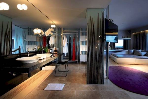 Badezimmer im Ushuaia Ibiza Beach Hotel mit Doppelwaschbecken, großer Dusche und Loungebereich.