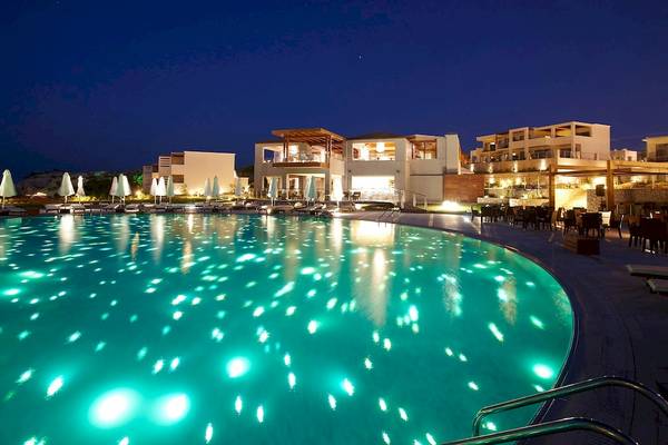 Der beleuchtete Pool im Sentido Port Royal Villas & Spa bei Nacht.