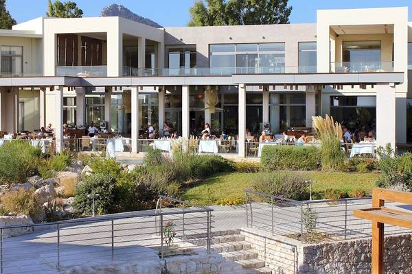 Außenbereich des Sentido Port Royal Villas & Spa Hotels mit Gästen, die drinnen und draußen essen