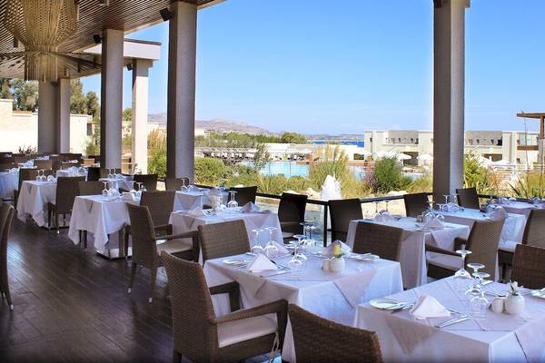 Innenansicht des Restaurants im Hotel Sentido Port Royal Villas & Spa mit vielen gedeckten Tischen und einem Blick auf den Swimmingpool.