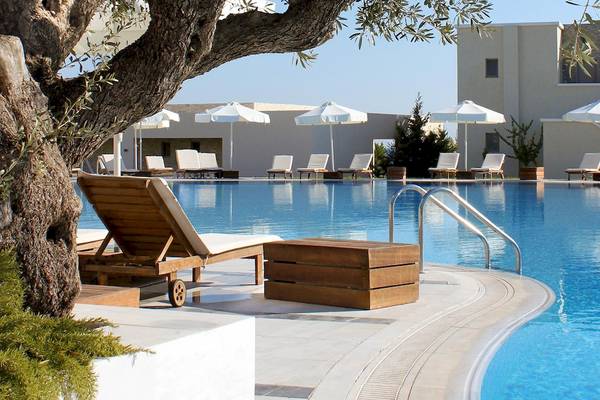 Außenpool des Sentido Port Royal Villas & Spa mit weißen Sonnenliegen und Schirmen