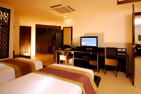 Zwei Betten in einem Hotelzimmer des Anyavee Tubkaek Beach Resort mit Schreibtisch und Fernseher.