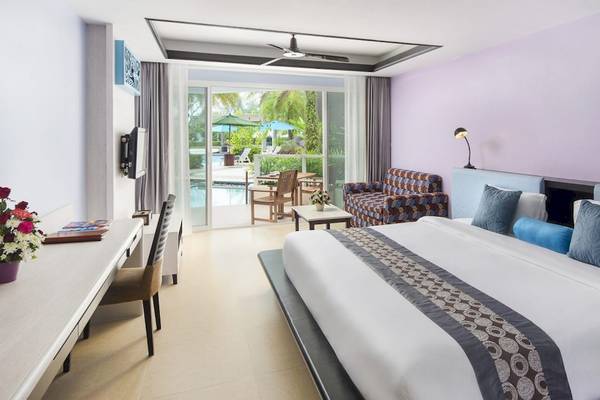 Zimmer im Anyavee Tubkaek Beach Resort mit Blick auf den Pool und Garten.