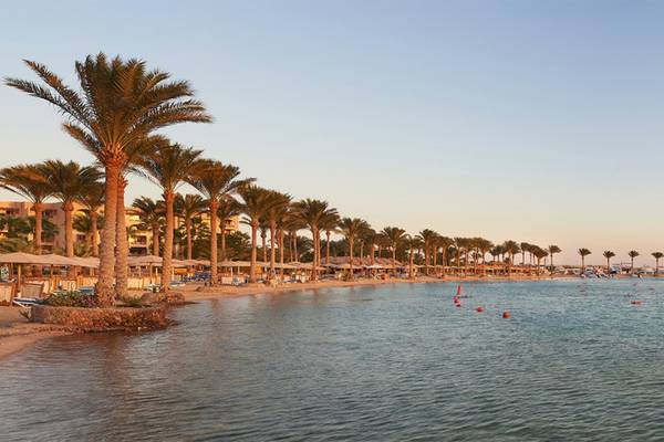 Strand des Continental Hotel Hurghada mit Palmen und Wasser