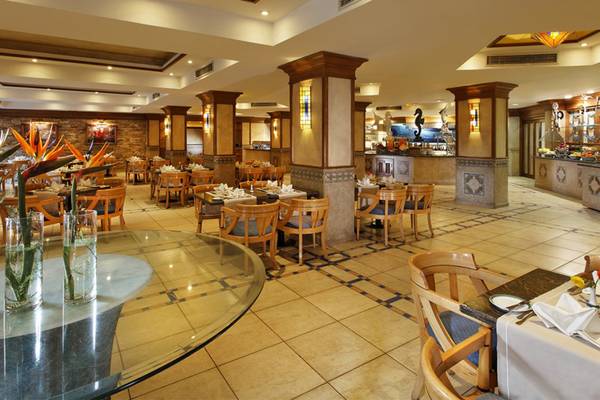 Innenansicht des Restaurants im Continental Hotel Hurghada mit runden Tischen und Stühlen.