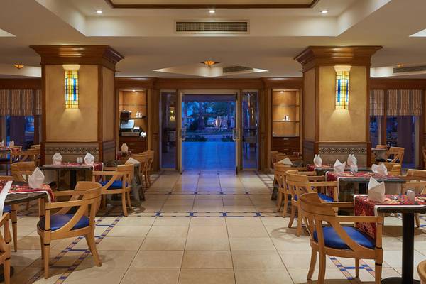 Innenansicht des Restaurants im Continental Hotel Hurghada mit gefliestem Boden und blauen Stühlen.