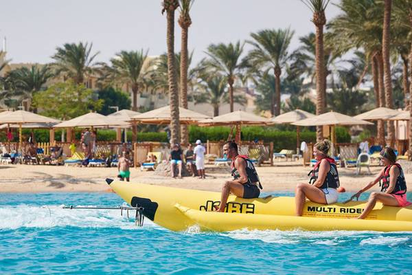 Drei Personen sitzen auf einem gelben Banana Boot am Strand des Continental Hotels Hurghada.