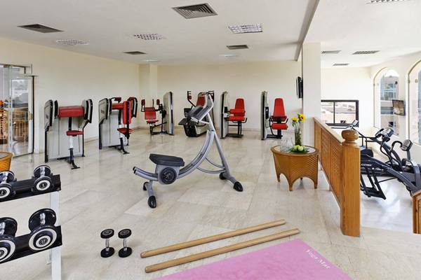 Fitnessstudio im Continental Hotel Hurghada mit verschiedenen Geräten und einer Yogamatte.