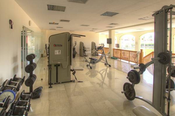 Fitnessraum im Continental Hotel Hurghada mit verschiedenen Trainingsgeräten und einer großen Fensterfront.