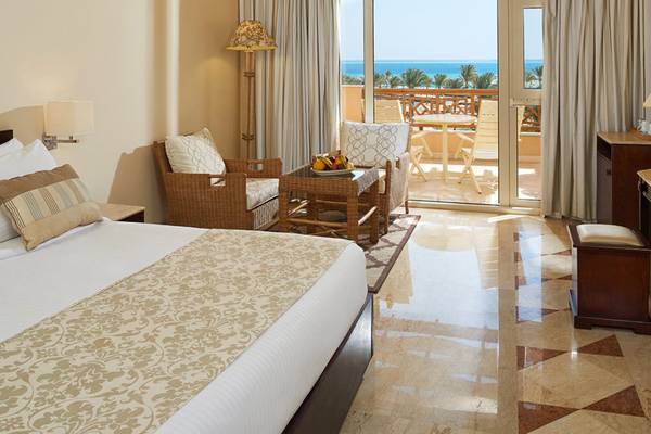 Zimmer im Continental Hotel Hurghada mit Balkon und Meerblick, inklusive Bett, Stühle und Tisch mit Obst