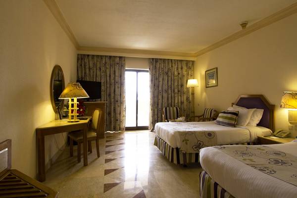 Doppelzimmer im Continental Hotel Hurghada mit zwei Betten, Schreibtisch und Fernseher.