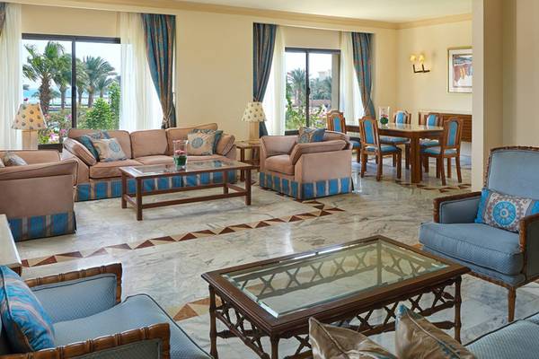 Wohnbereich im Continental Hotel Hurghada mit Sofas, Tisch und Fenstern.