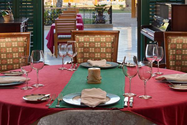 Ein elegant gedeckter Tisch im Continental Hotel Hurghada mit roten Tischdecken und Glaswaren.