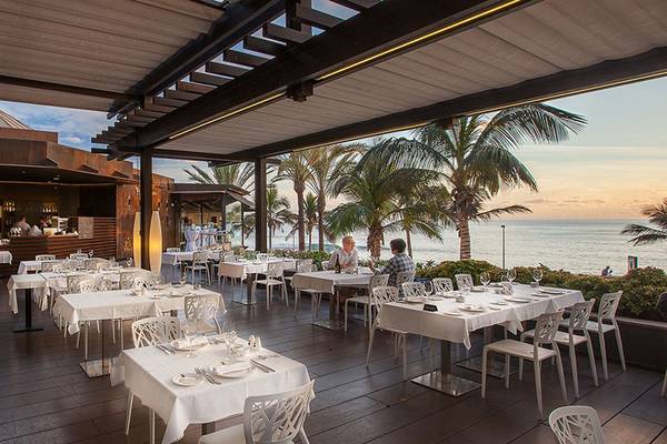 Außenbereich des Restaurants im Lopesan Costa Meloneras Resort & Spa mit Blick auf das Meer und Palmen