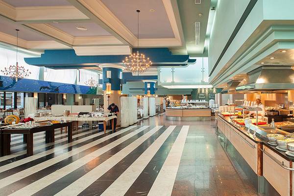 Innenansicht des Buffet-Restaurants im Lopesan Costa Meloneras Resort & Spa mit verschiedenen Speisen und einem Koch, der Speisen zubereitet.