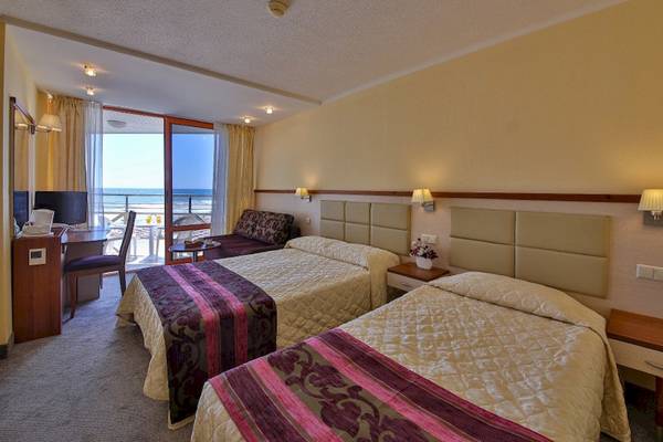 Doppelzimmer im Kaliakra Beach Hotel mit Balkon und Meerblick, zwei Betten, Schreibtisch, Fernseher und Fenster mit Blick auf das Meer.