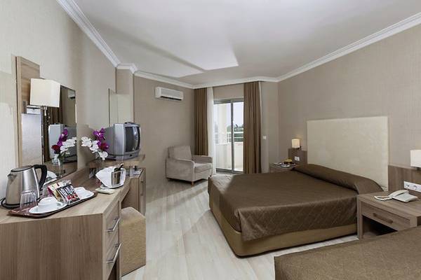 Doppelzimmer im Calimera Hane Garden Hotel mit zwei Betten, Schreibtisch und Balkon.