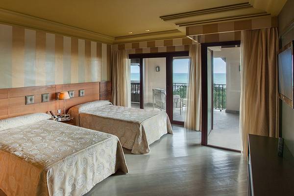 Doppelzimmer im Lopesan Costa Meloneras Resort & Spa mit zwei Betten, einem Balkon und Meerblick.