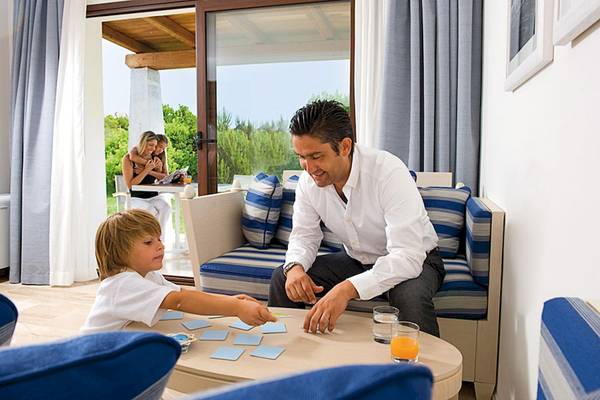 Vater und Sohn spielen im Wohnzimmer des Grande Baia Resort & Spa.