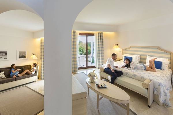 Zwei Erwachsene und zwei Kinder entspannen sich in einem Schlafzimmer des Grande Baia Resort & Spa.