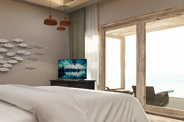 Schlafzimmer mit Bett, Fernseher und Meerblick im You & Me Maldives