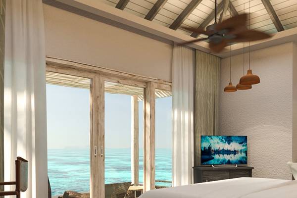 Schlafzimmer mit Meerblick im You & Me Maldives Hotel mit offenem Balkon und Fernseher.