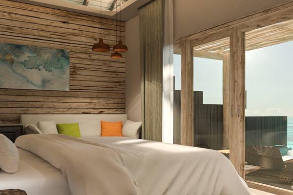 Schlafzimmer mit Meerblick im You & Me Maldives Hotel mit Holzwänden, Bett und Fenstern.